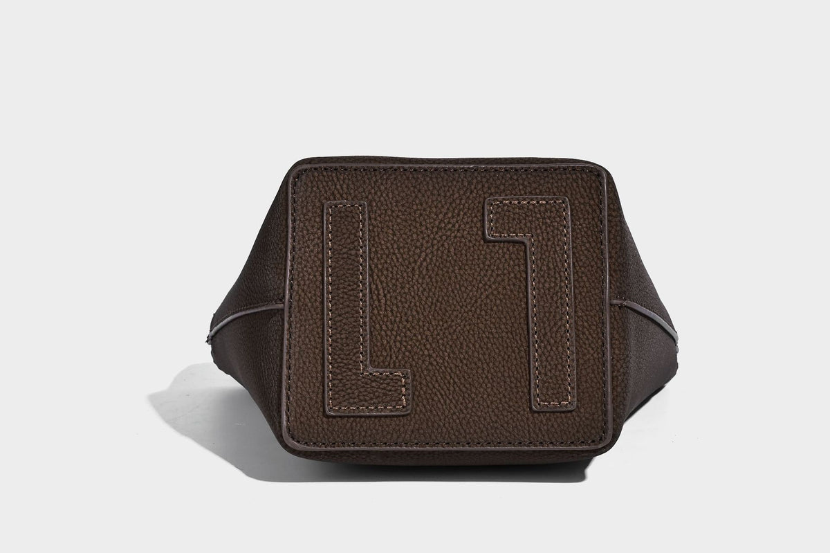 Kleine matte Beuteltasche mit genarbter Oberfläche, antikgoldfarbenen Ringbeschlägen, Perlen- und Quastenanhänger, kurzen Tragegriffen oben und
