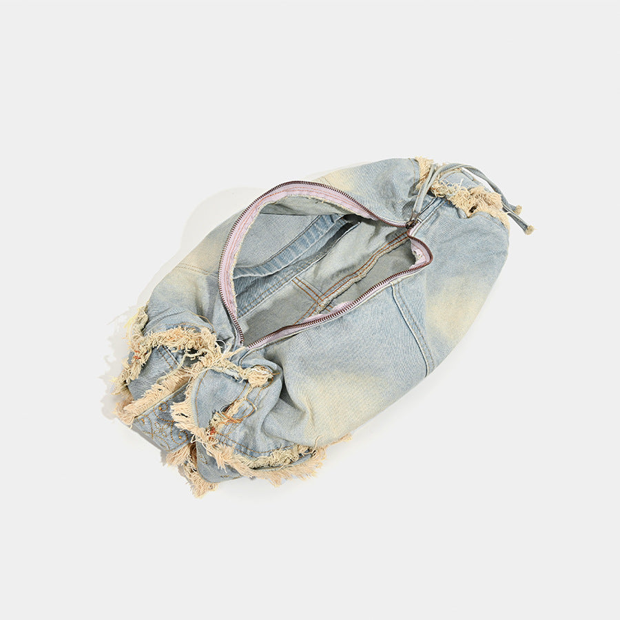 Large slouchy washed denim shoulder bag with frayed raw-edge trim and zip-top closure, detail view 4
