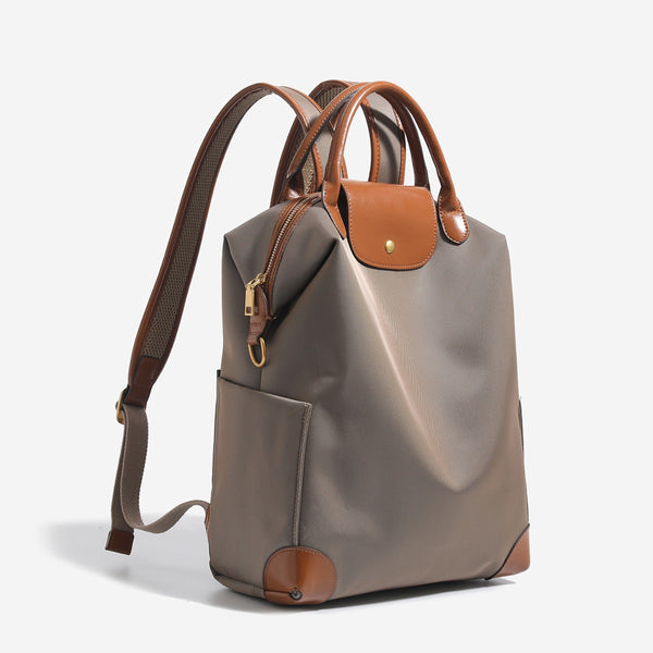 Large matte nylon backpack handbag with cognac leather-look trim, snap flap, and gold-tone hardware, detail view 3