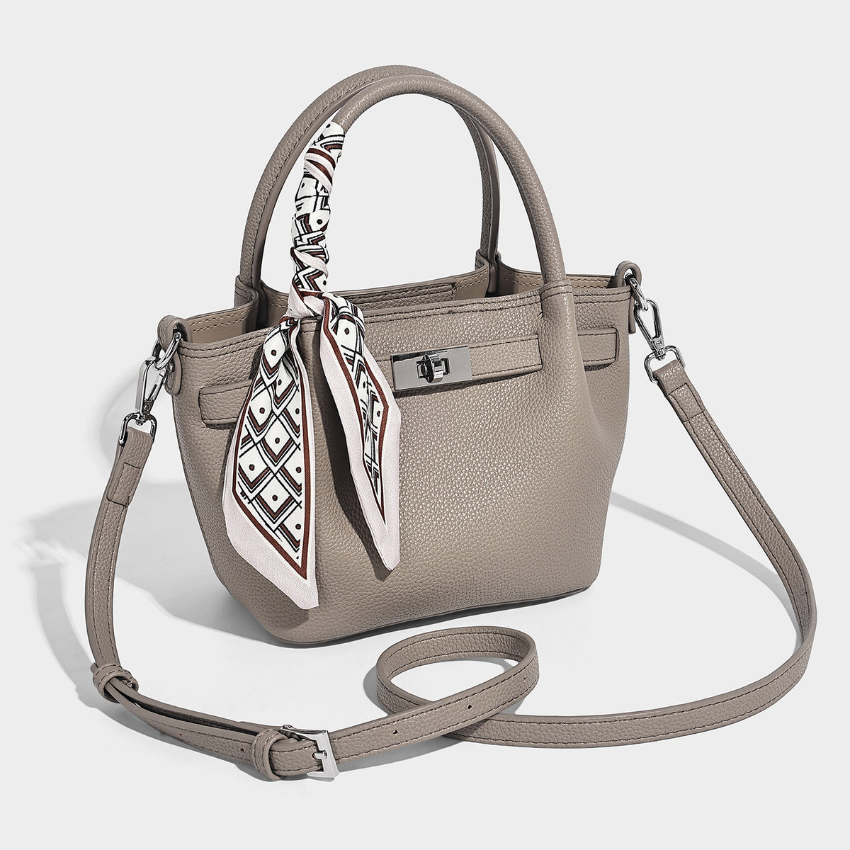 Small structured pebbled tote satchel in taupe with dual top handles, printed scarf tie, front turn-lock closure, and, front