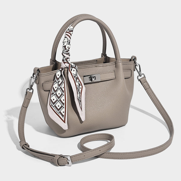Kleine strukturierte Henkeltasche aus genarbtem Material in Taupe mit zwei Henkeln, bedrucktem Schalband, vorderem Drehverschluss und, Vorderansicht