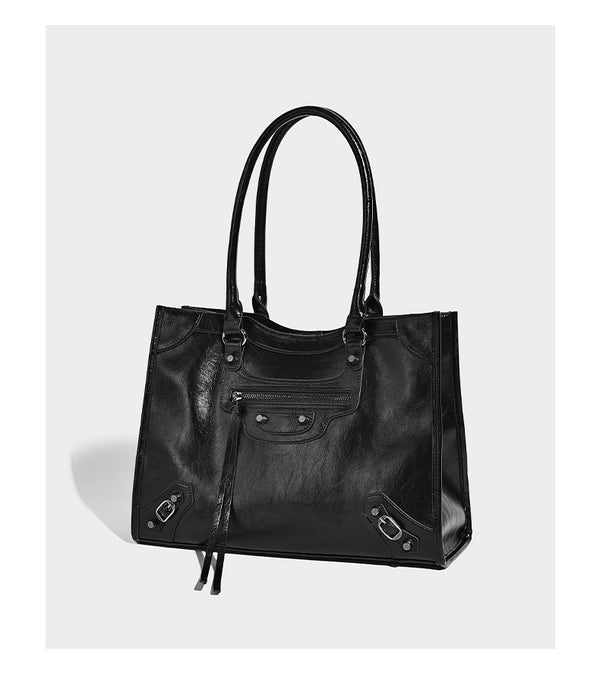 Large structured leather-look tote bag with front zip pocket, moto hardware accents, and long double shoulder straps, detail