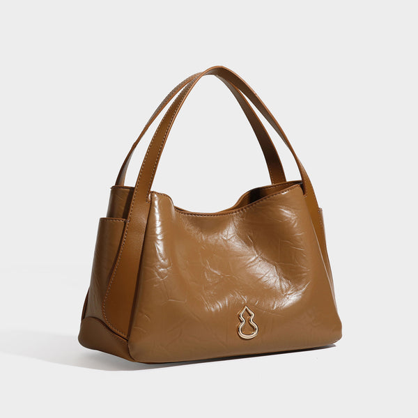 Black glossy crinkled leather-look convertible shoulder tote bag with gold gourd-shaped emblem hardware and detachable