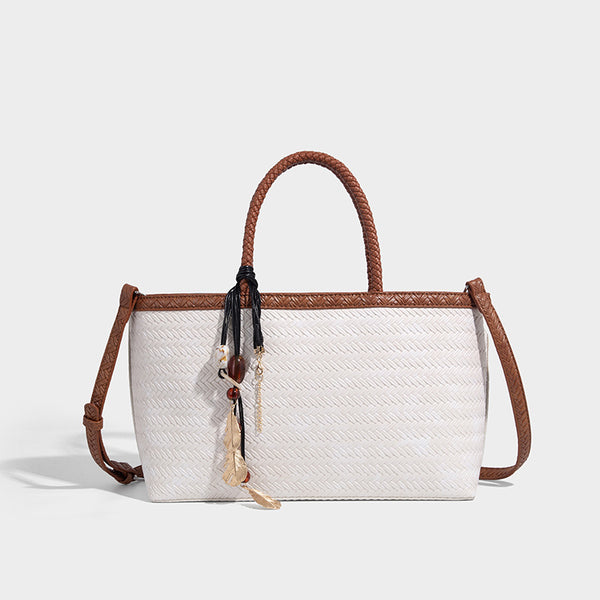 Structured woven-texture tote bag with brown braided top handles, decorative tassel charm, and detachable shoulder strap