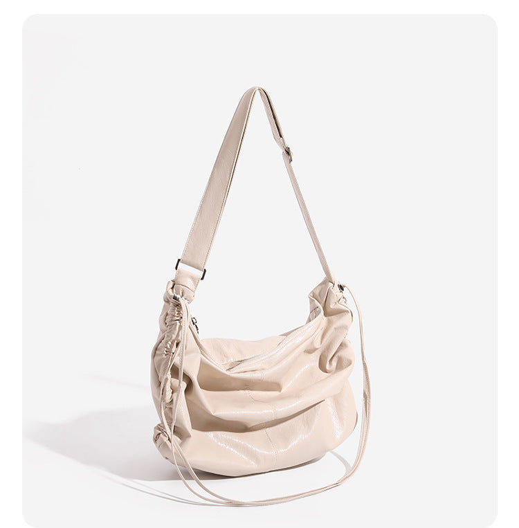 Oversized slouchy hobo shoulder bag with glossy crinkled leather-look finish, drawstring gathered sides, and silver-tone