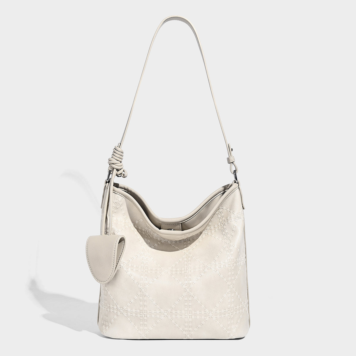 Diamond-quilted leather-look bucket shoulder bag with knotted strap accent and attached mini pouch, detail view 6