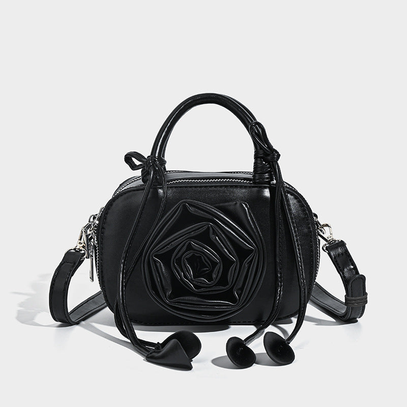 compact barrel bag with 3D rose appliqué, dual zip top, knotted handle, and adjustable crossbody strap, detail view 7