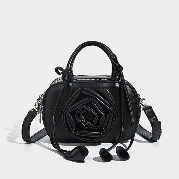 compact barrel bag with 3D rose appliqué, dual zip top, knotted handle, and adjustable crossbody strap, detail view 7