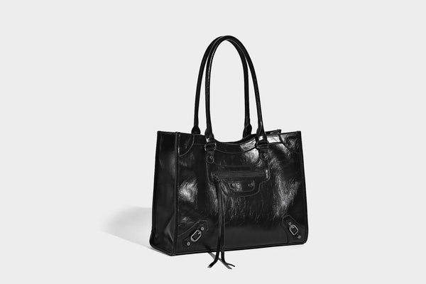 Large structured leather-look tote bag with front zip pocket, moto hardware accents, and long double shoulder straps, detail