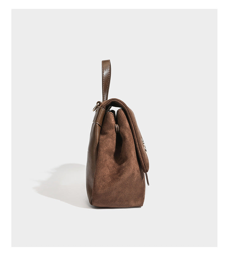 Formstabile Satchel-Tasche mit Überschlag in matter Veloursleder-Optik, goldfarbenen Emblem-Details, kurzem Tragegriff und verstellbarem Crossbody-Riemen