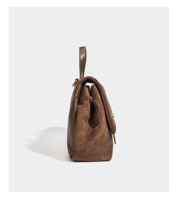 Formstabile Satchel-Tasche mit Überschlag in matter Veloursleder-Optik, goldfarbenen Emblem-Details, kurzem Tragegriff und verstellbarem Crossbody-Riemen