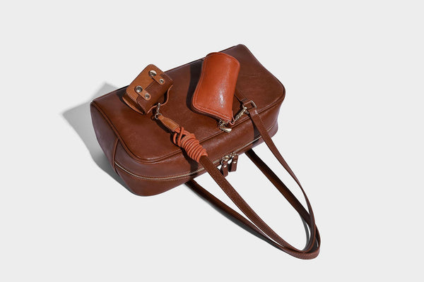 Strukturierte Boston-Schultertasche in glänzender Lederoptik mit zwei langen Trageriemen, Reißverschluss oben, goldfarbenen Beschlägen und zwei