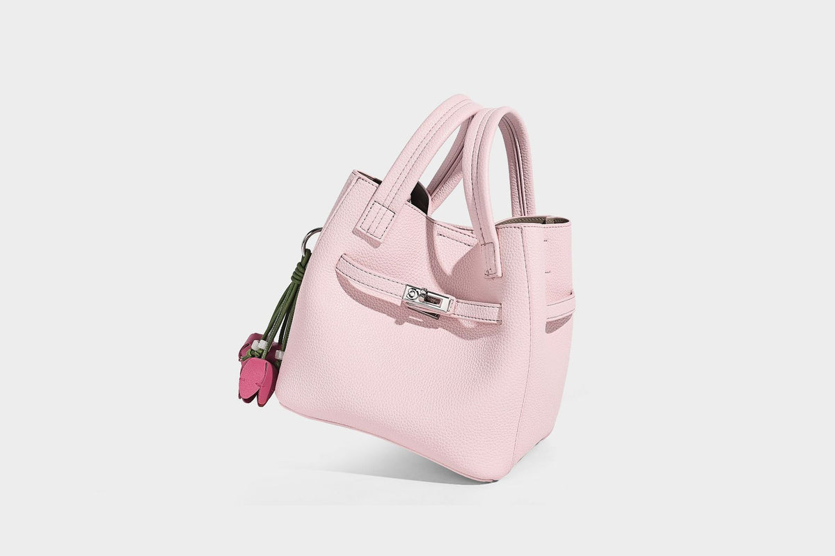 Small structured pebbled bucket tote bag with dual top handles, silver turn-lock front pocket, and detachable shoulder strap