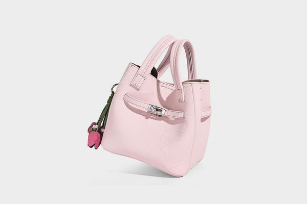 Small structured pebbled bucket tote bag with dual top handles, silver turn-lock front pocket, and detachable shoulder strap