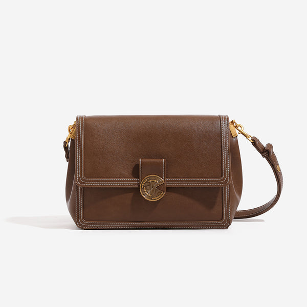Structured flap shoulder bag with gold-tone circular turn-lock closure, white contrast stitching, and adjustable strap, front