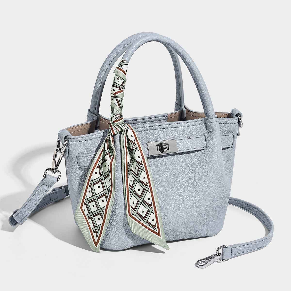 Kleine strukturierte Henkeltasche aus genarbtem Material in Taupe mit zwei Henkeln, bedrucktem Schalband, vorderem Drehverschluss und, Detailansicht