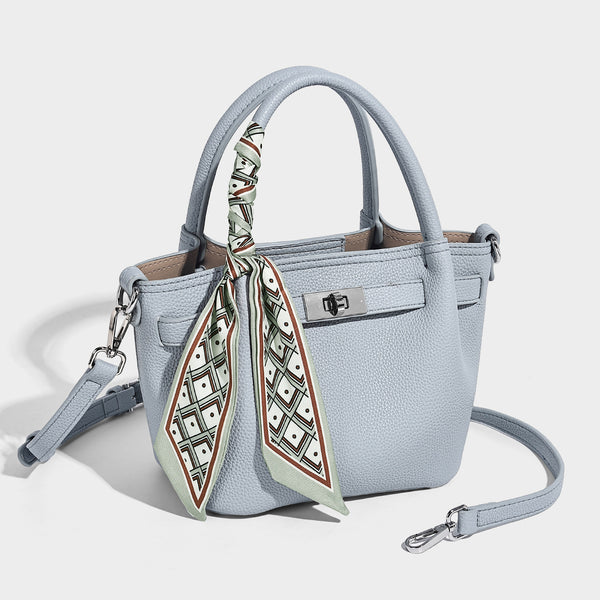 Kleine strukturierte Henkeltasche aus genarbtem Material in Taupe mit zwei Henkeln, bedrucktem Schalband, vorderem Drehverschluss und, Detailansicht