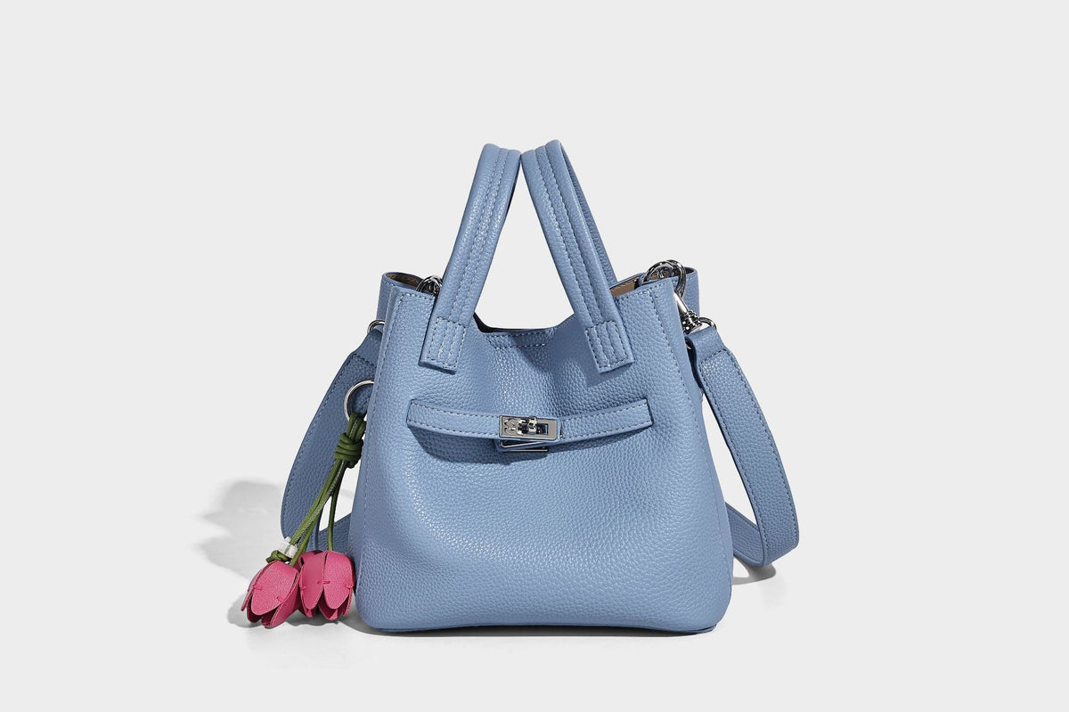 Small structured pebbled bucket tote bag with dual top handles, silver turn-lock front pocket, and detachable shoulder strap