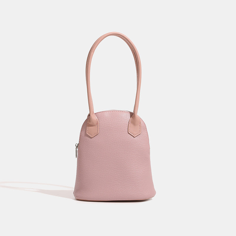 Rounded shell handbag with pebbled leather-look finish, dual top handles, and silver-tone zipper, detail view 6