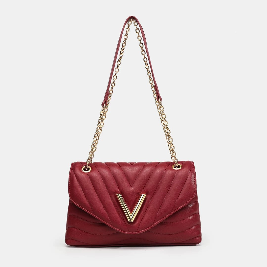 Small structured diamond-quilted flap shoulder bag with gold-tone V-shaped hardware and chain strap, front view