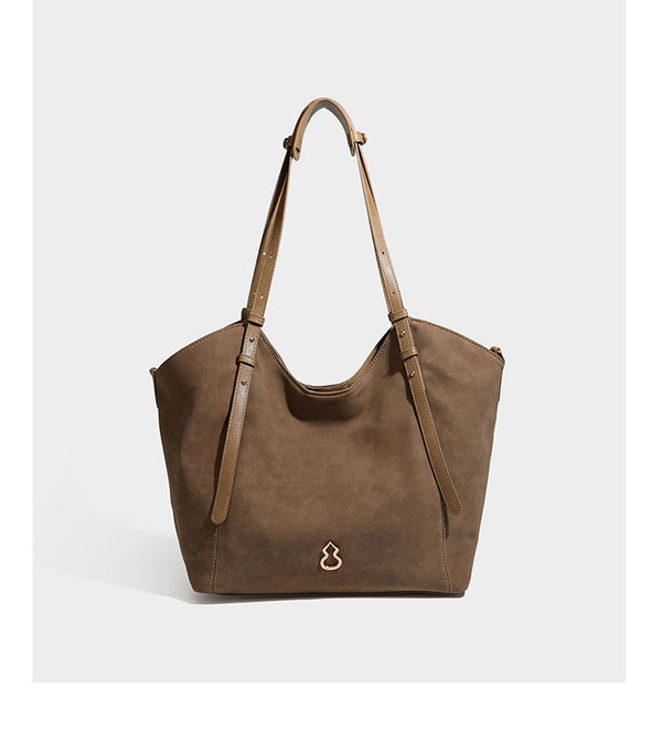 Oversized suede-finish tote shoulder bag in caramel brown with slim leather-look straps and gold-tone logo hardware, detail
