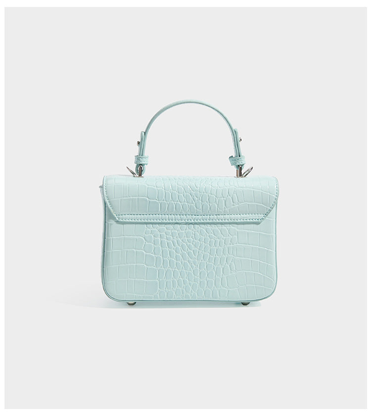 Small structured rectangular satchel with glossy crocodile-embossed finish, arched top handle, front flap, and silver-tone