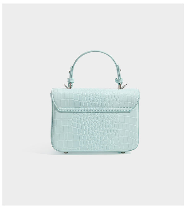 Small structured rectangular satchel with glossy crocodile-embossed finish, arched top handle, front flap, and silver-tone