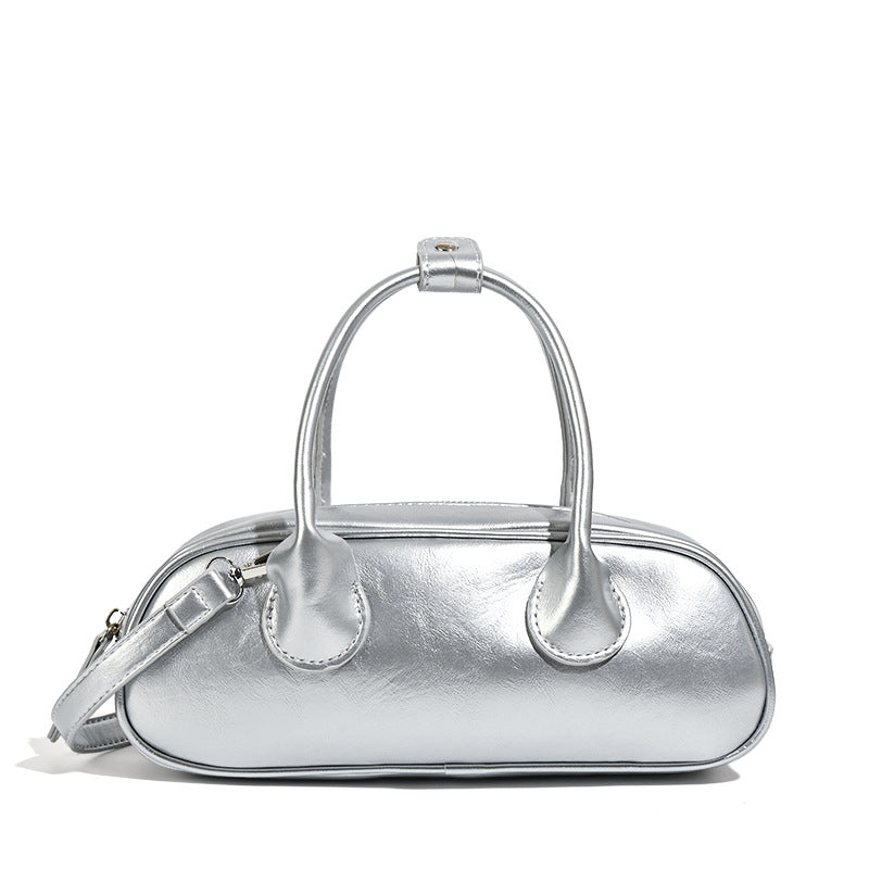 Kompakte silberfarbene Mini-Boston-Tasche mit zwei Tragegriffen oben, silberfarbenen Metallelementen und abnehmbarem Crossbody-Riemen, Detailansicht