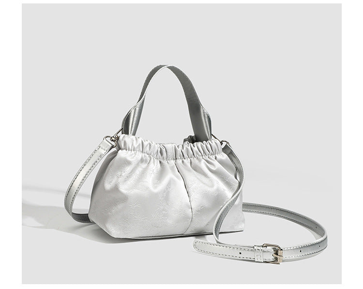 Small ruched satin-finish cloud bag with elasticized drawstring top, short top handle, and chunky silver-tone chain strap
