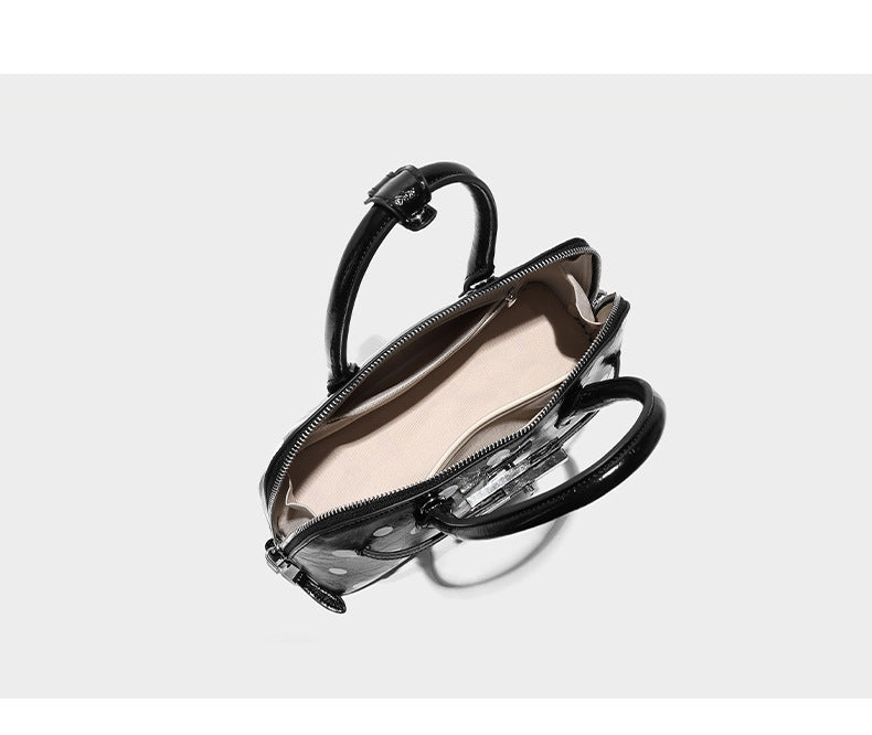 Structured polka-dot Boston bag with glossy crinkled finish, dual top handles, silver-tone turn-lock clasp, and detachable