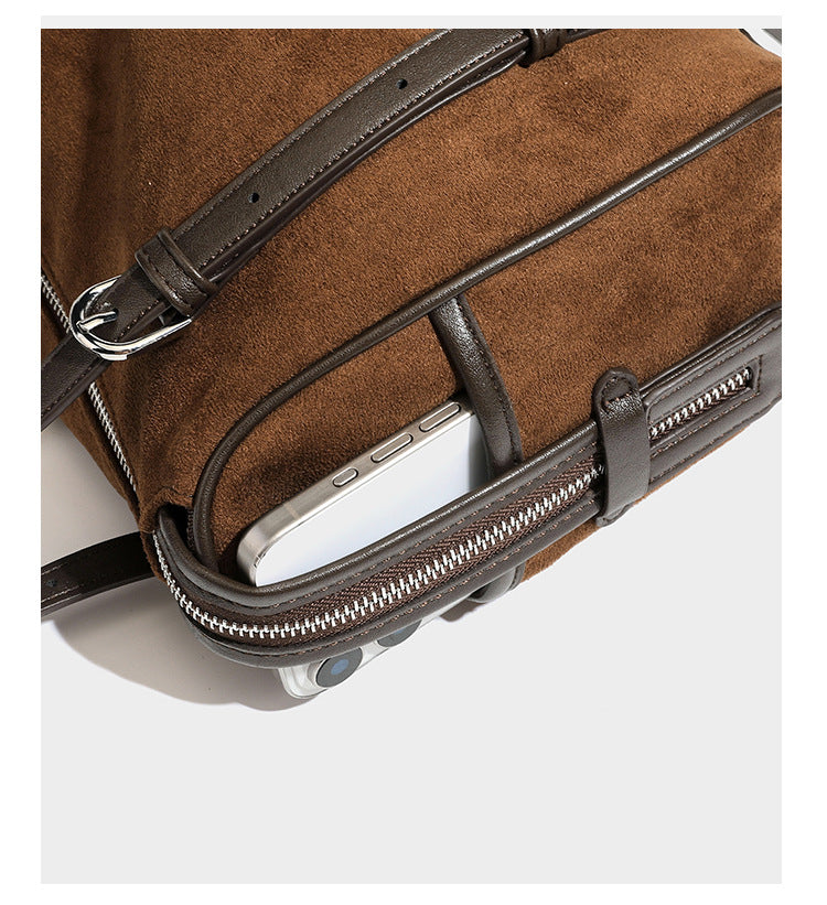 Large brown suede-finish barrel shoulder bag with dark leather-look trim, silver-tone zippers, dual top handles, and long