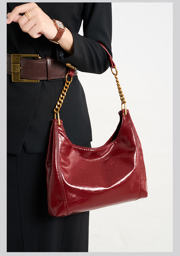 Glossy leather-look hobo shoulder bag with gold-tone chain-and-leather strap in deep burgundy red, detail view 9