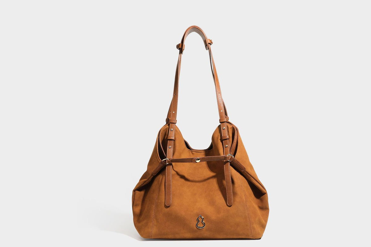 Oversized suede-finish tote shoulder bag in caramel brown with slim leather-look straps and gold-tone logo hardware, detail