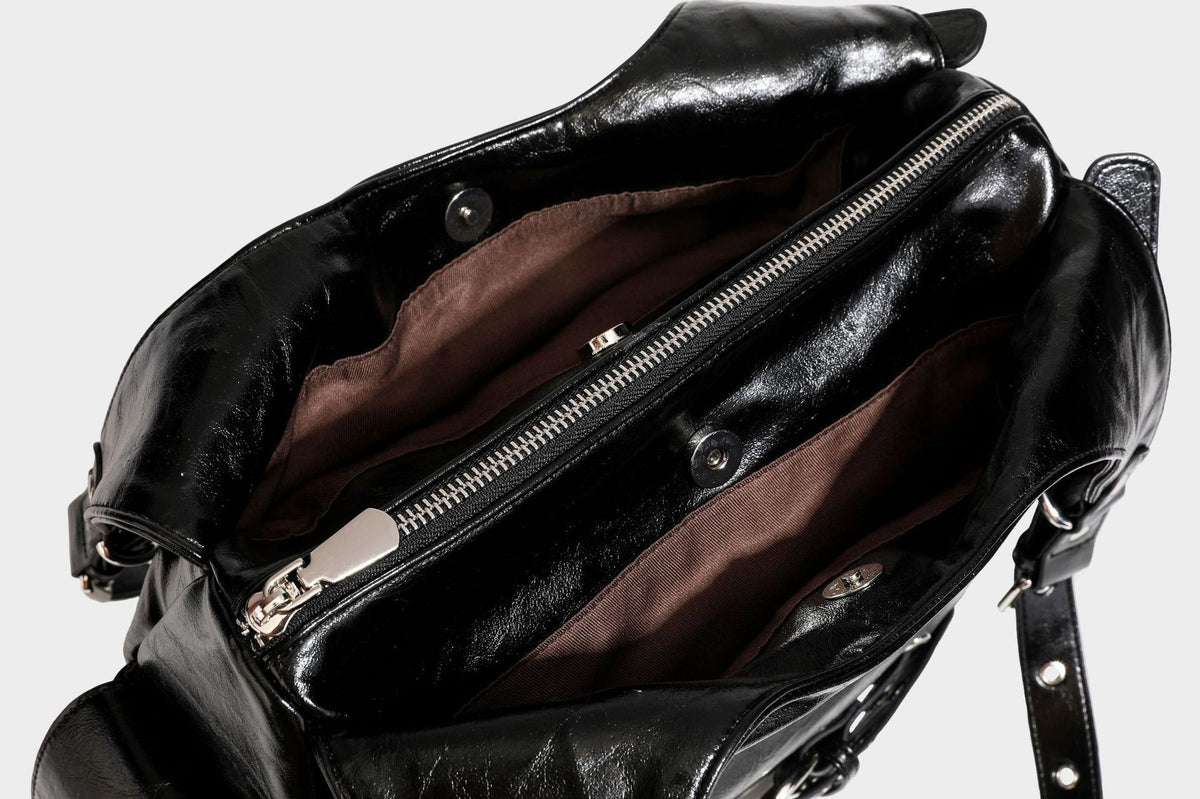 Große glänzende schwarze Hobo-Schultertasche mit silberfarbenem Ösen-Gürtelboden, Schnallenbeschlägen, vorderer Reißverschlusstasche und zwei …; Detailansicht