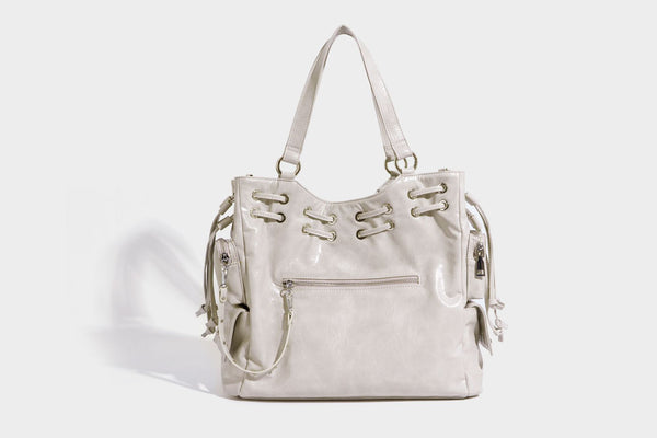 Glossy crinkled leather-look tote bag with silver grommet lace-up front detail, dual top handles, and detachable shoulder