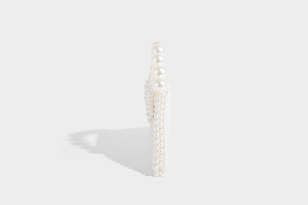 Small structured triangle clutch bag covered in glossy pearl beads with an arched pearl top handle and silver snap closure
