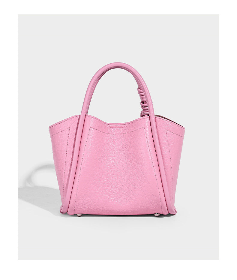 Structured mini tote bag in pebbled leather-look finish with knotted top handles, front flap pocket, and detachable shoulder