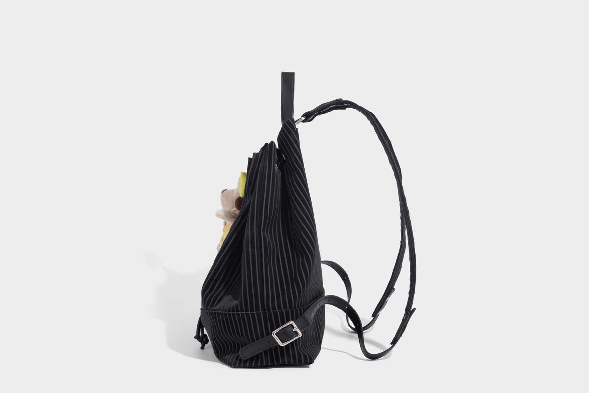 Schwarze wandelbare Rucksack-Handtasche mit Nadelstreifen, Kordelzugverschluss, Tragegriff aus Lederimitat und matten Metallbeschlägen, Detailansicht