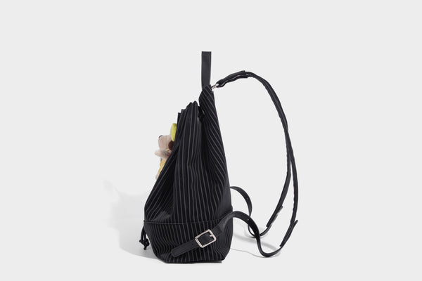 Schwarze wandelbare Rucksack-Handtasche mit Nadelstreifen, Kordelzugverschluss, Tragegriff aus Lederimitat und matten Metallbeschlägen, Detailansicht