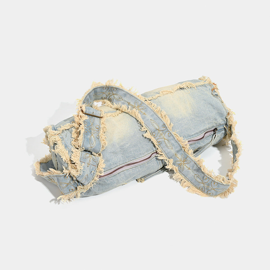 Large slouchy washed denim shoulder bag with frayed raw-edge trim and zip-top closure, detail view 3