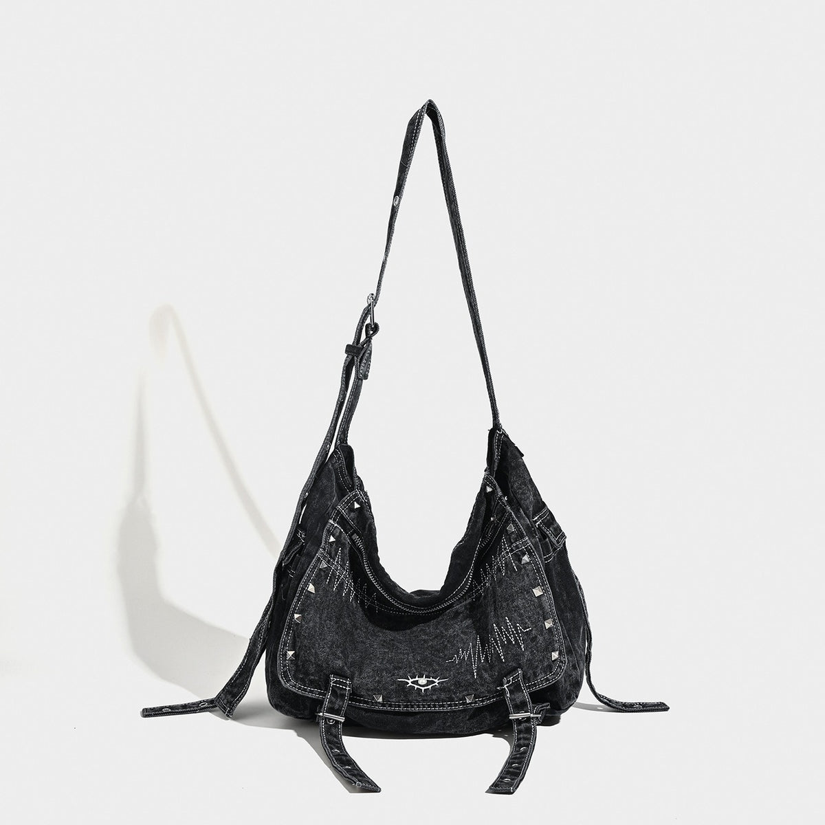 Large washed black denim hobo shoulder bag with silver rivet accents and adjustable crossbody strap, front view