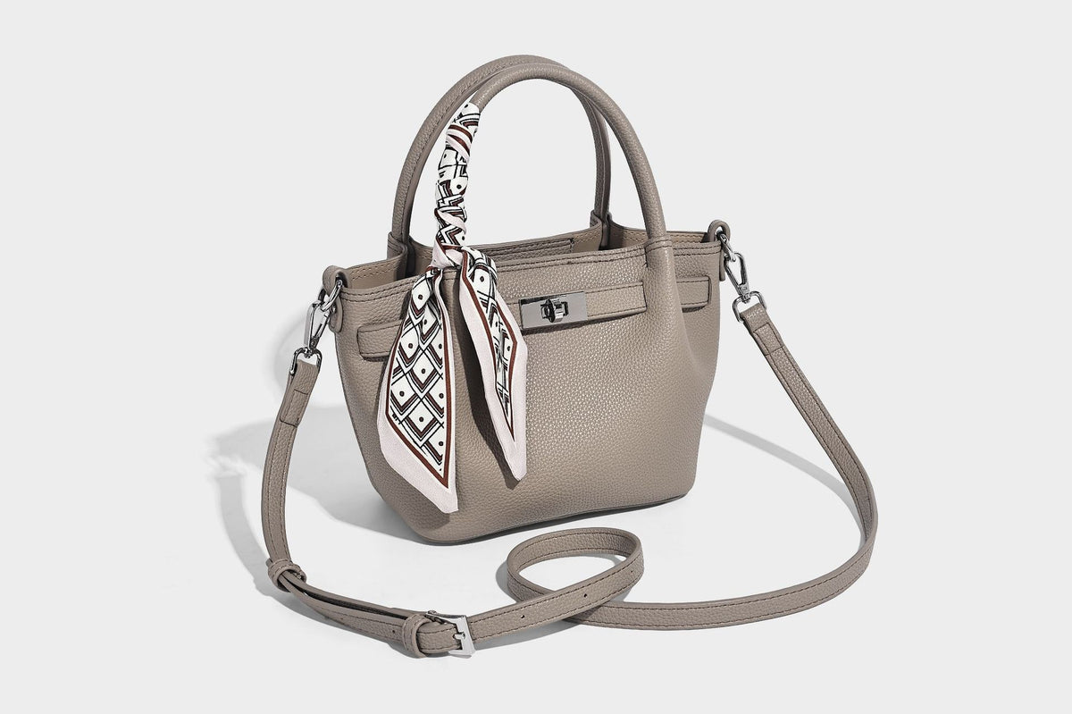 Kleine strukturierte Henkeltasche aus genarbtem Material in Taupe mit zwei Henkeln, bedrucktem Schalband, vorderem Drehverschluss und, Detail