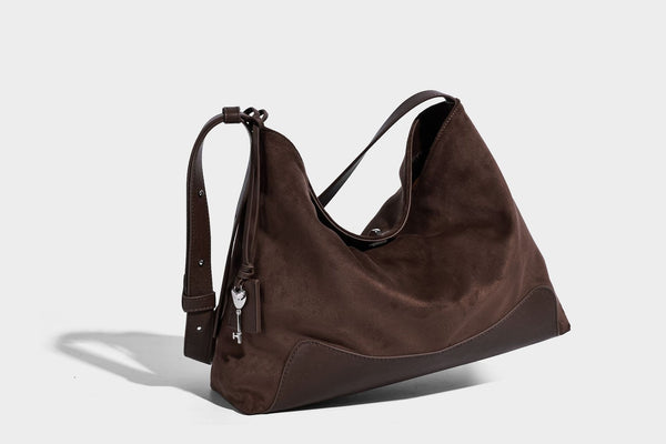 Dark brown slouchy hobo bag with matte suede-look body, smooth leather-look base trim, adjustable shoulder strap, and, detail