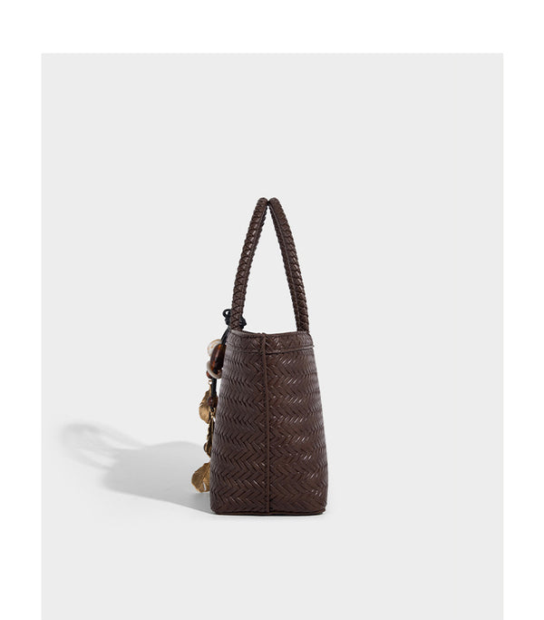 Structured chevron woven leather-look tote bag with braided top handles, gold feather charm, and adjustable shoulder strap