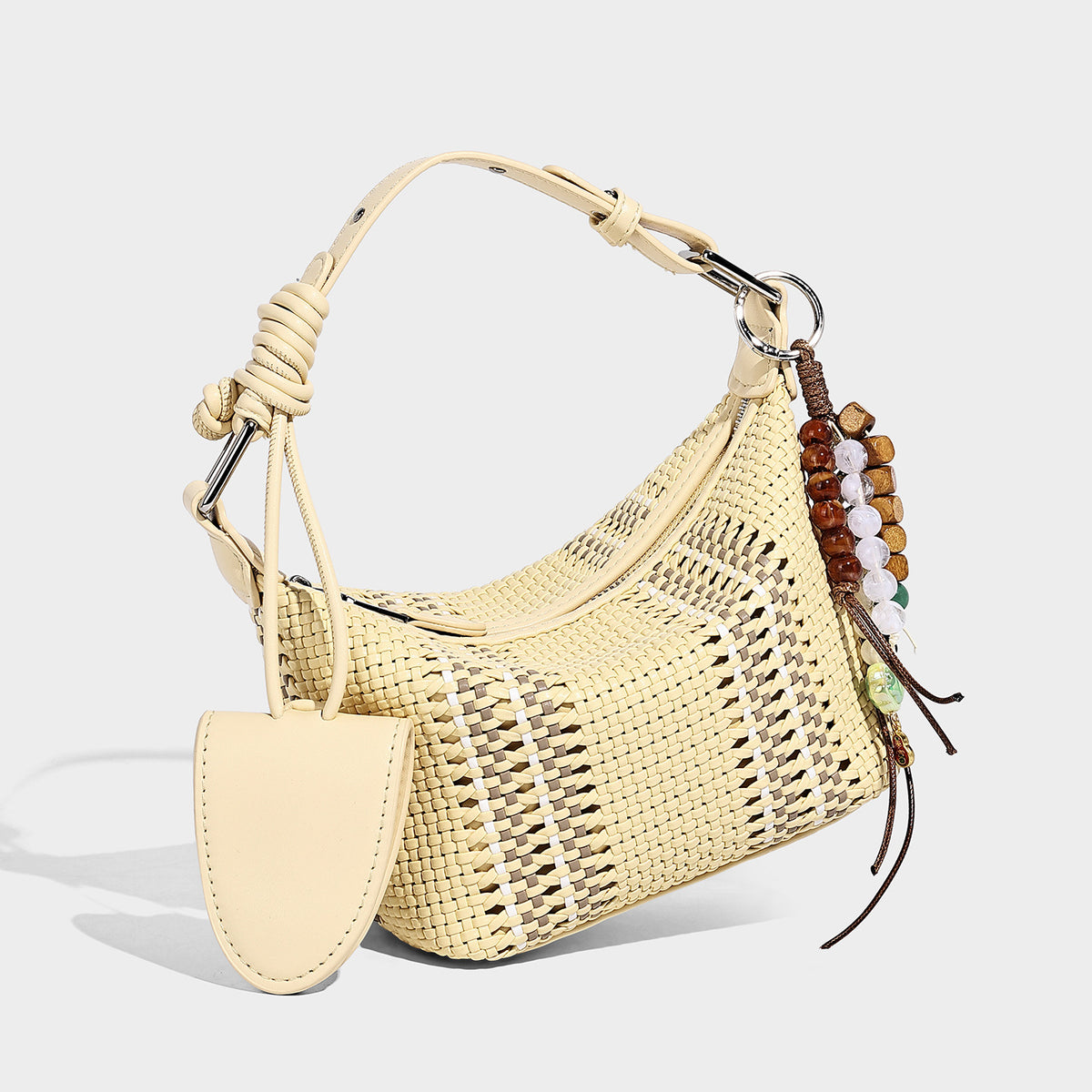 Small woven crescent shoulder bag with leather-look trim, zip closure, silver-tone ring hardware, and beaded tassel charm