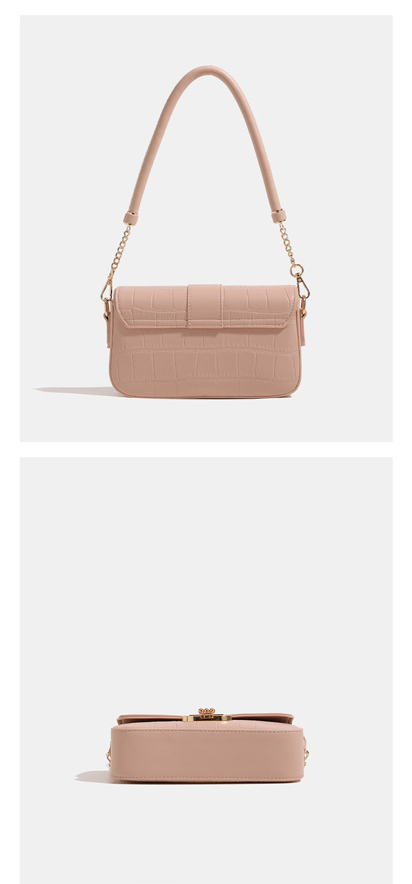 Small structured crocodile-embossed flap shoulder bag with circular gold turn-lock closure and chain-accent strap, detail