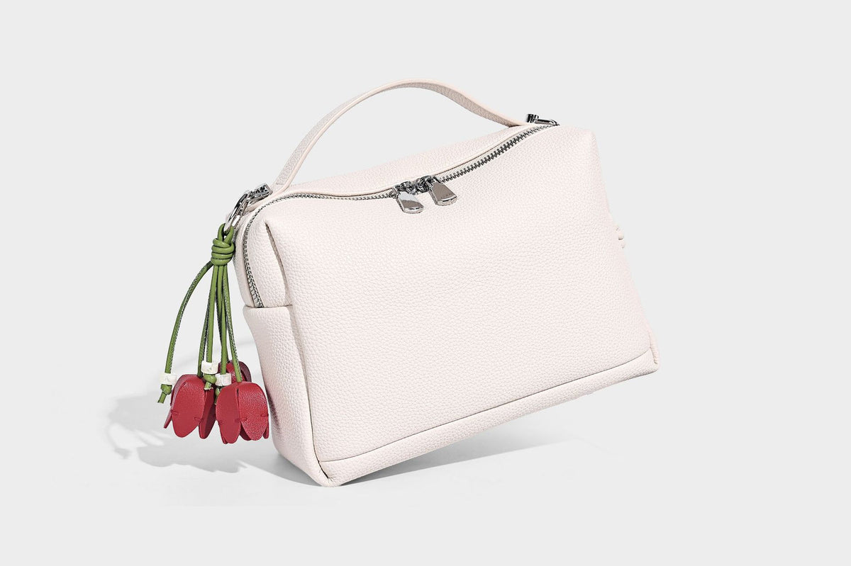 Kleine strukturierte Crossbody-Tasche mit Tragegriff aus genarbtem Material, Reißverschluss, silberfarbenen Beschlägen und optionalem Quastenanhänger