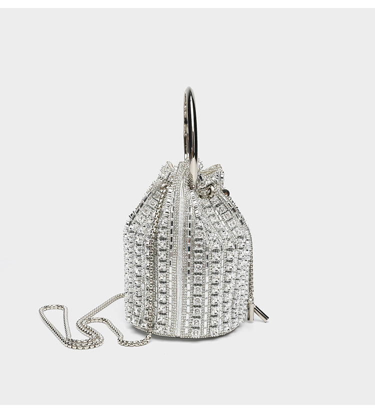 Mini crystal rhinestone bucket bag with circular ring top handle, drawstring closure, and silver chain shoulder strap, detail