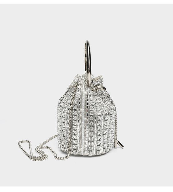 Mini crystal rhinestone bucket bag with circular ring top handle, drawstring closure, and silver chain shoulder strap, detail
