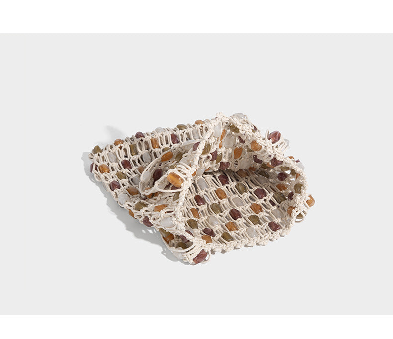 Cream macramé open-weave tote bag with multicolor amber olive and translucent bead accents and woven shoulder straps, detail